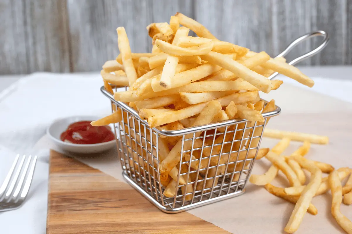 A close-up of golden French fries cooking in an air fryer, creating a crispy and delicious snack.