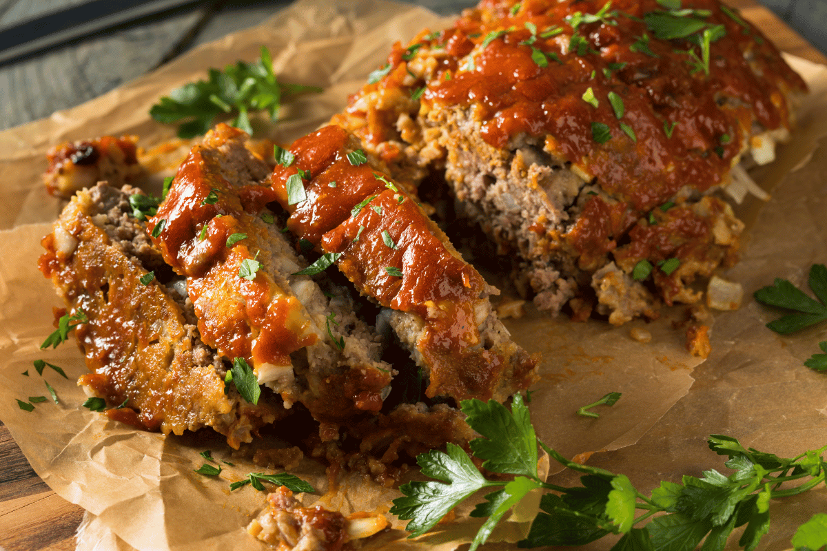 Delicious meatloaf slices arranged on a plate, ready to be served with a side of homemade sauce.