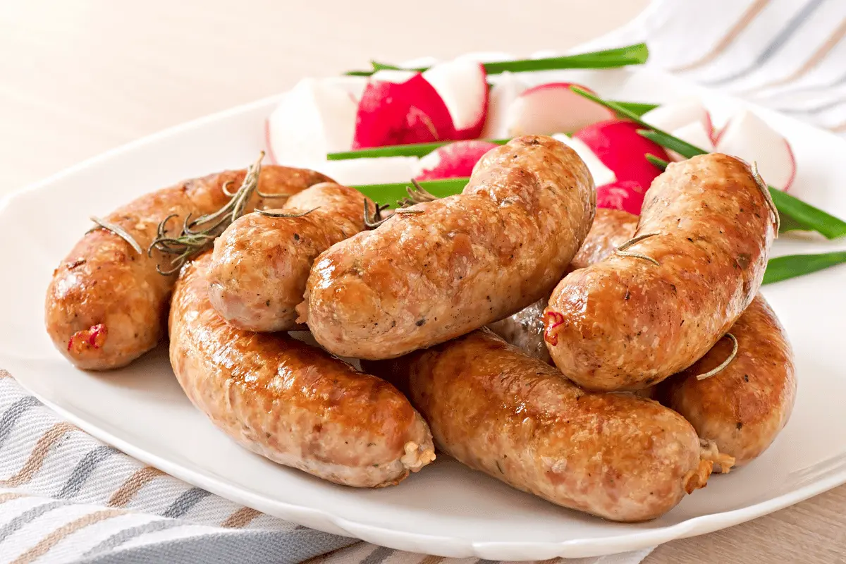 A plate of sausages, radishes, and green onions, creating a colorful and appetizing dish.
